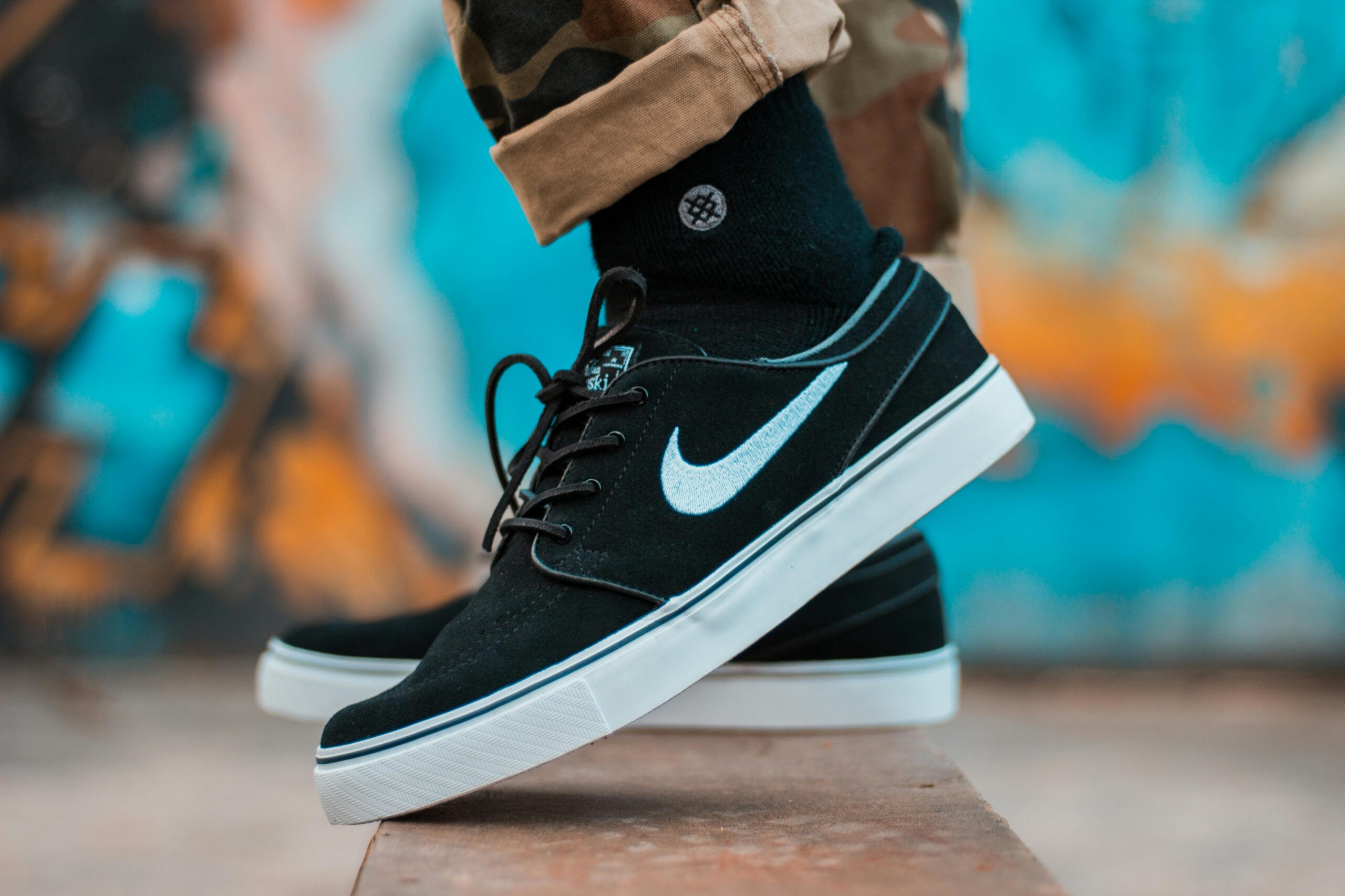 pexels photo 1478442 1478442 Close-up of black sneakers with camouflage pants, showcasing urban style.